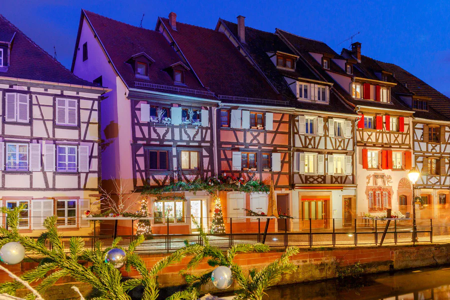 Casas con entramado de madera junto a un canal de Colmar, decoradas con luces de Navidad