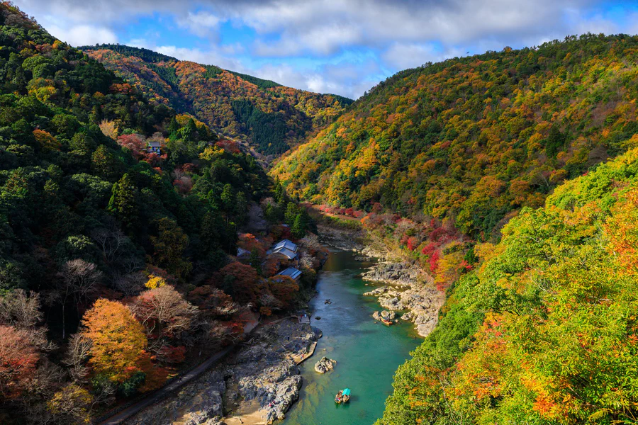 Il fiume Hozu serpeggia tra montagne coperte dai colori dell'autunno vicino ad Arashiyama