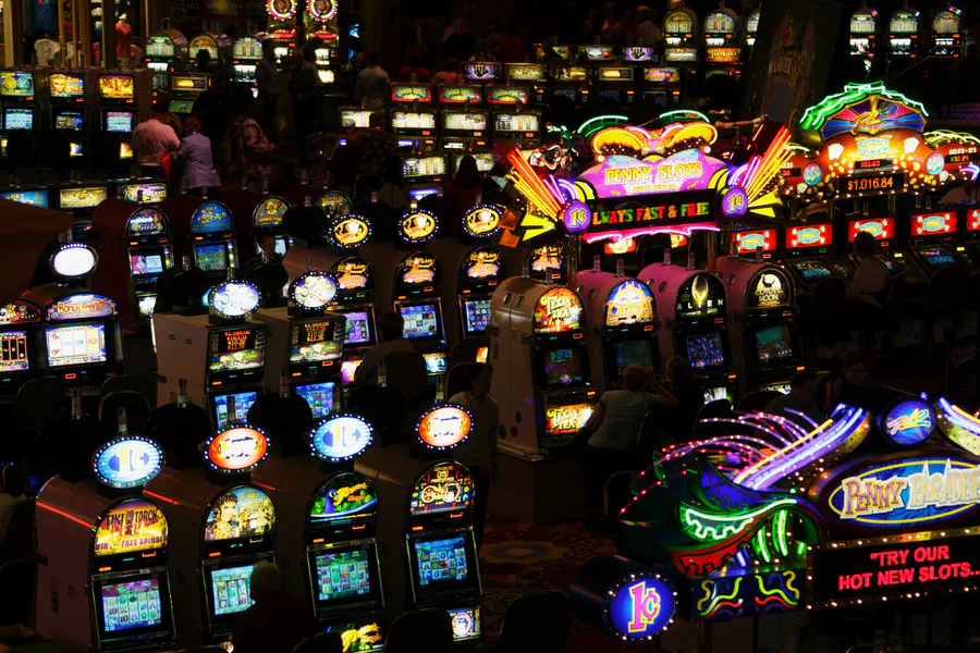 File di slot machine illuminate nella penombra di un casino a Las Vegas