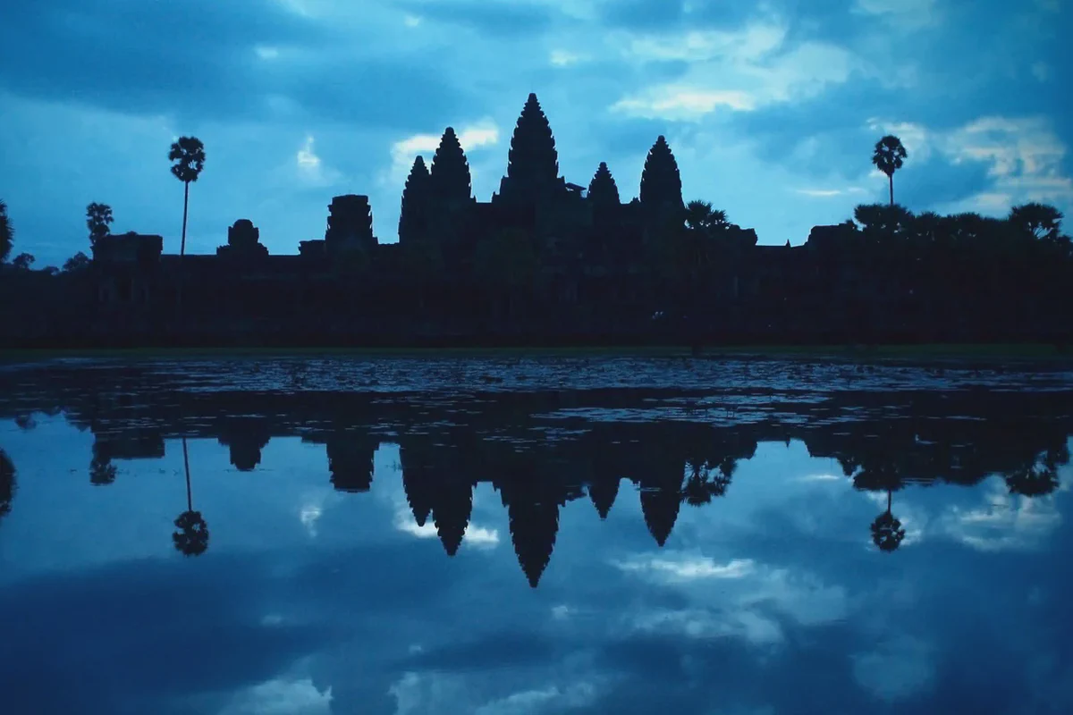 Le torri di Angkor Wat in controluce all'alba, riflesse nello stagno