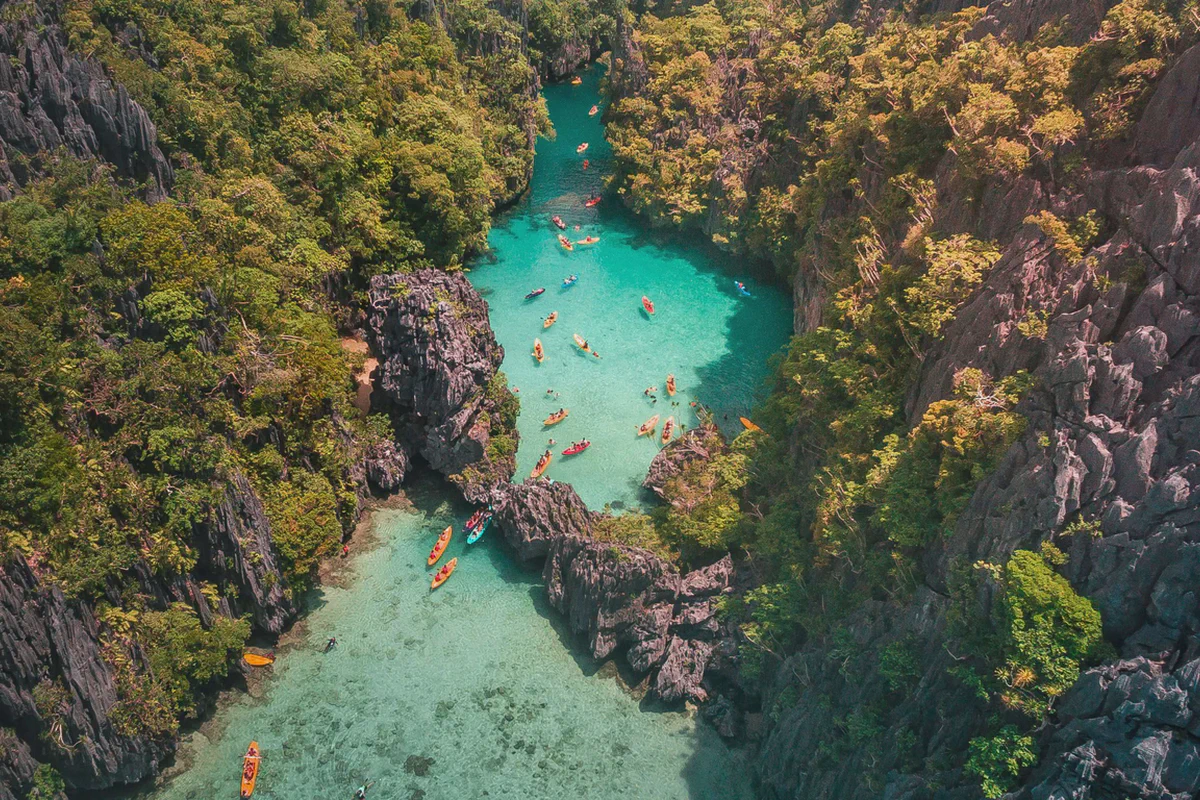 Kayak in una laguna turchese tra falesie calcaree a Palawan