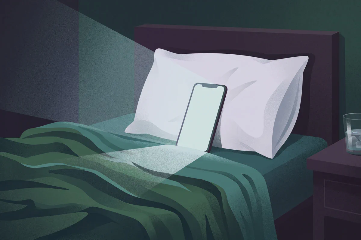 A phone propped on a hotel bed playing a film, the room dark around it