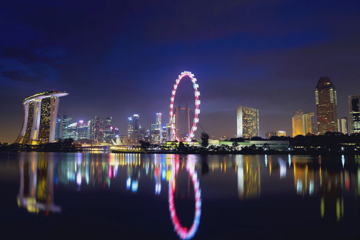 Marina Bay Sands, the Singapore Flyer and the city skyline at night, reflected in still water
