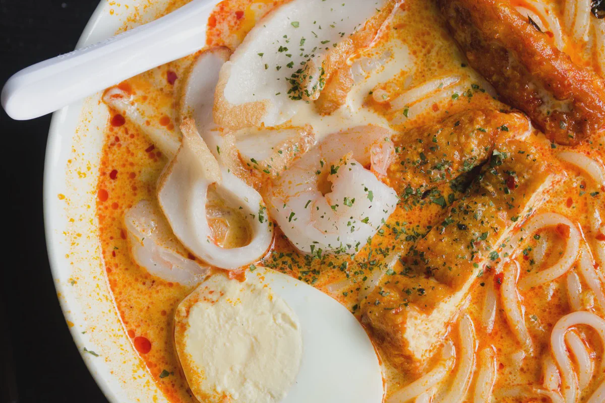 Una ciotola di laksa con gamberi, tofu e uovo sodo